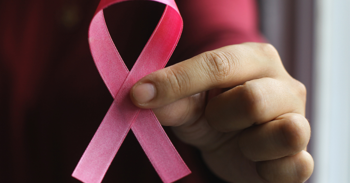 woman's hand holding pink breast cancer awareness ribbon. Beyond the pink ribbon: How cause marketing drives real change. Shift•logy Communication