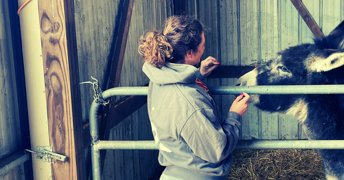Shift•ology CEO Melanie Wilt in barn with donkey