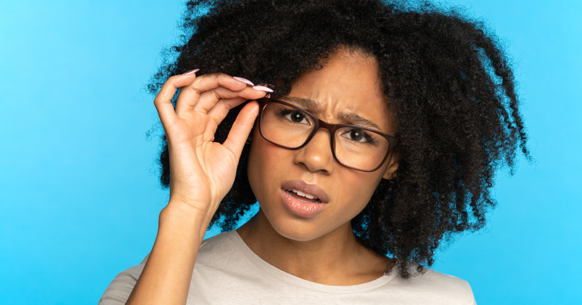 PR_MeaningBlogImage Woman touch glasses on her face with confused look. Light blue background.